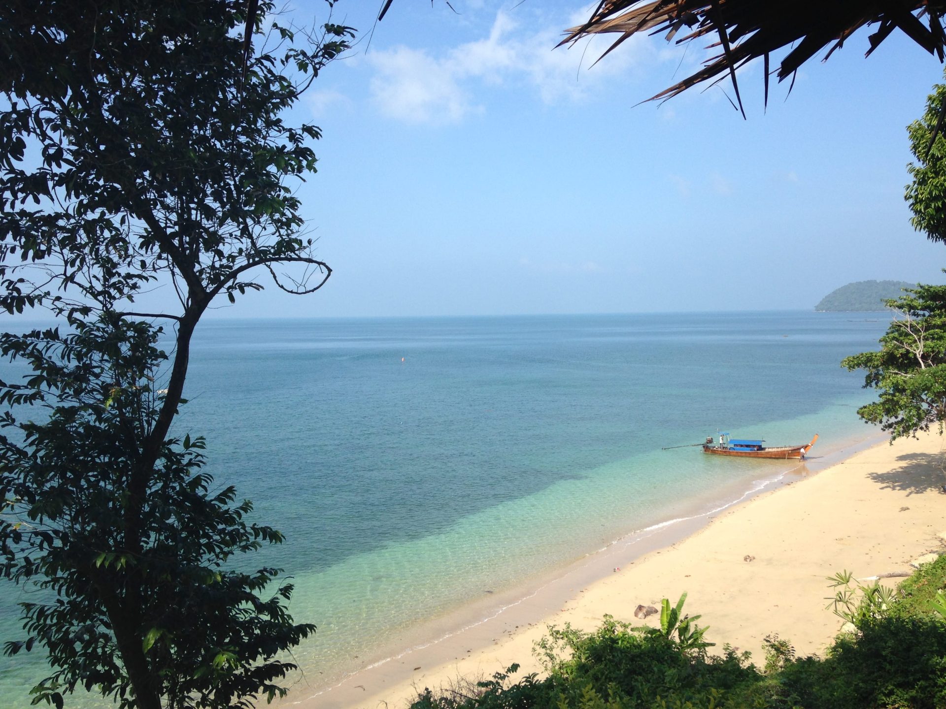Travel photo of an exotic beach paradise with a longtail boat in the turquoise waters.