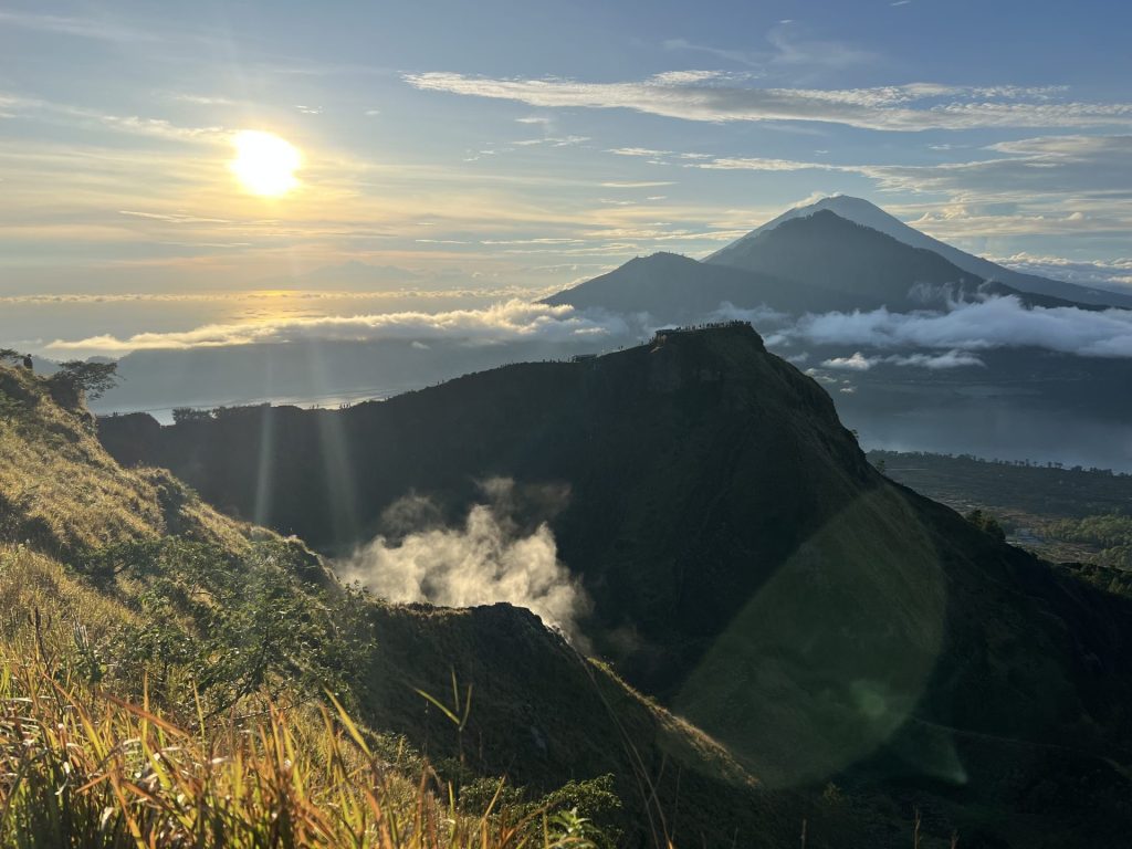 Photo from a mountain with the sun highlighting the volcanic thermal steam rising.