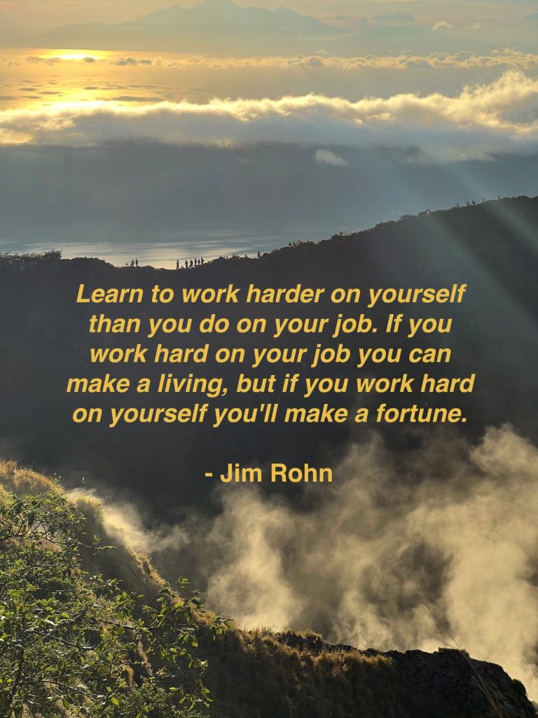 A Jim Rohn quote about the power of personal growth overlayed a strong photo taken form the top of a mountain.