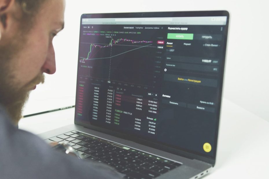 Photo of a man searching for the best CFD broker on his laptop.