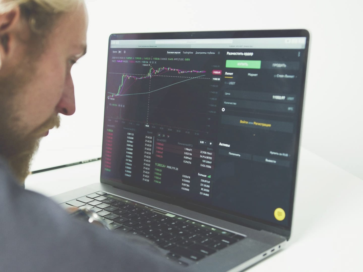 Photo of a man searching for the best CFD broker on his laptop.