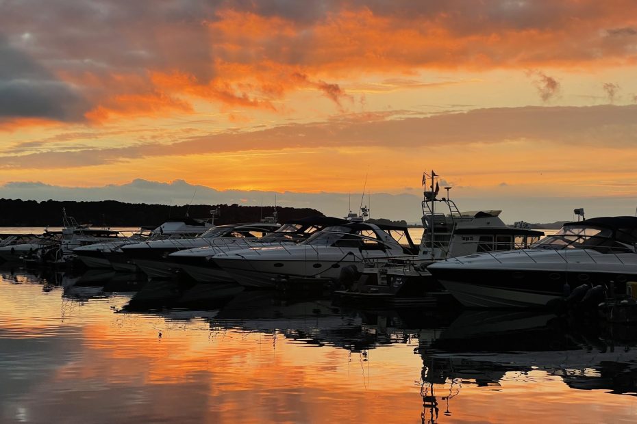 Photo of a sunset with fiery colours over a marina showing the power of personal growth.