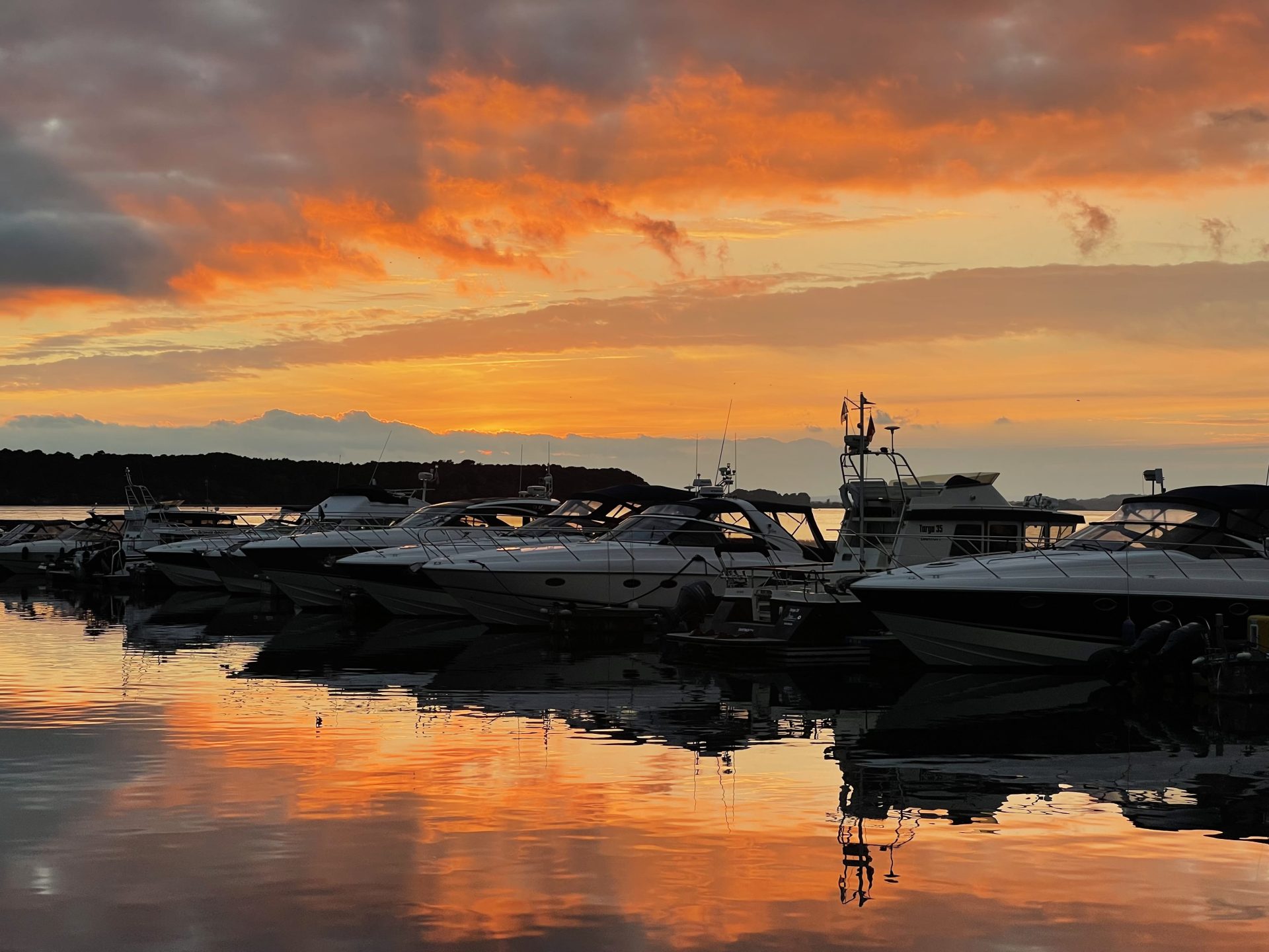 Photo of a sunset with fiery colours over a marina showing the power of personal growth.